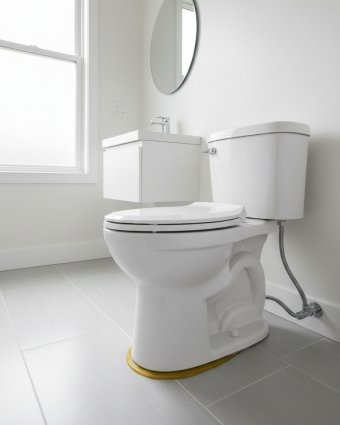 Plumber installing pipes under a kitchen sink with tools and plumbing supplies nearby.